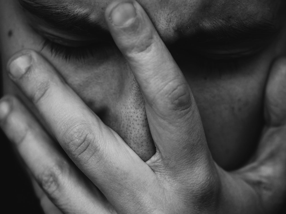 A man covering his face with his hand